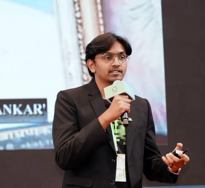 Mohammed Kabeer speaking on stage with a microphone