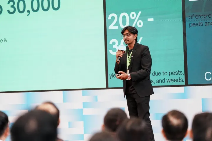 Mohammed Kabeer presenting in front of a slide of figures