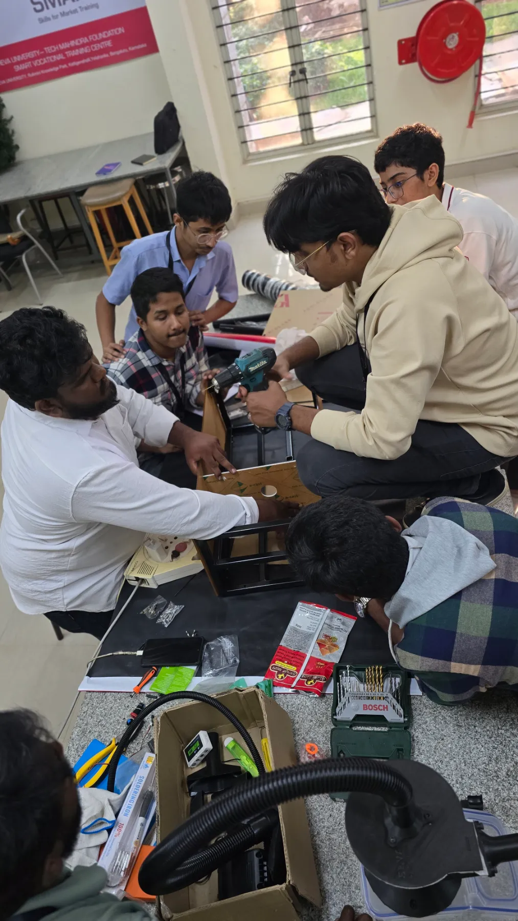 Team members assembling a device on the floor